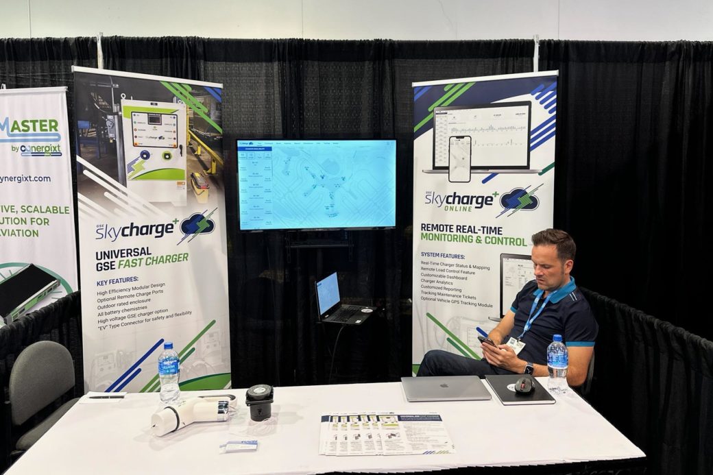 Booth with 2 large standing signs describing the Ravin Energy GSE Skycharge™ Fast Charger and Skycharge™ Online Platform